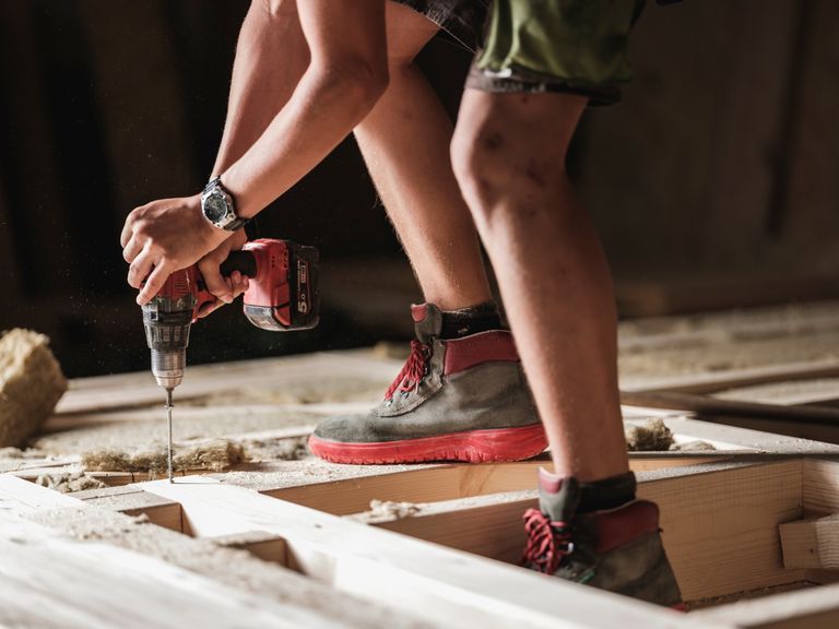 Handwerker mit Akku-Bohrmaschine bei Holzarbeiten Handwerker mit Akku-Bohrmaschine bei Holzarbeiten